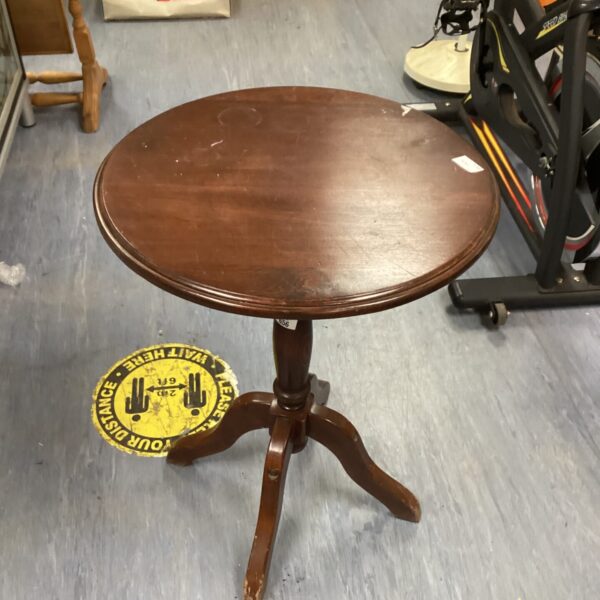 Antique mahogany wine table with a decorative wall mirror in the background.