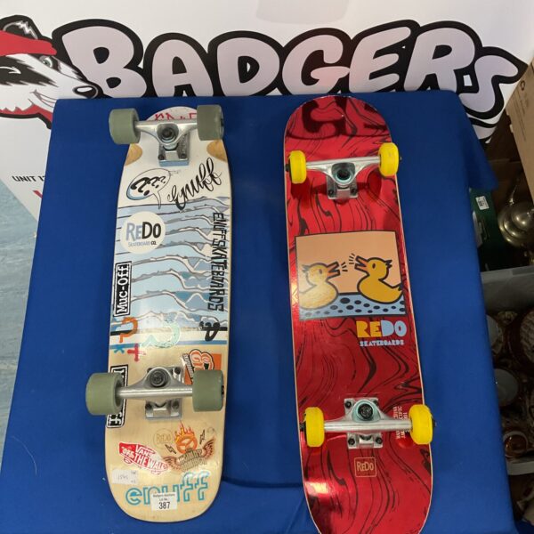 Redo skateboard with vibrant sticker-bomb graphic design.