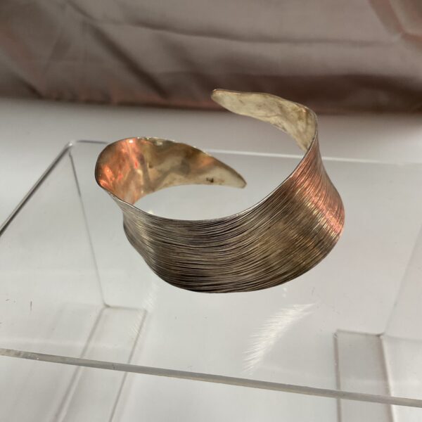 Vintage silver bangle with ridged texture, a classic jewellery piece.