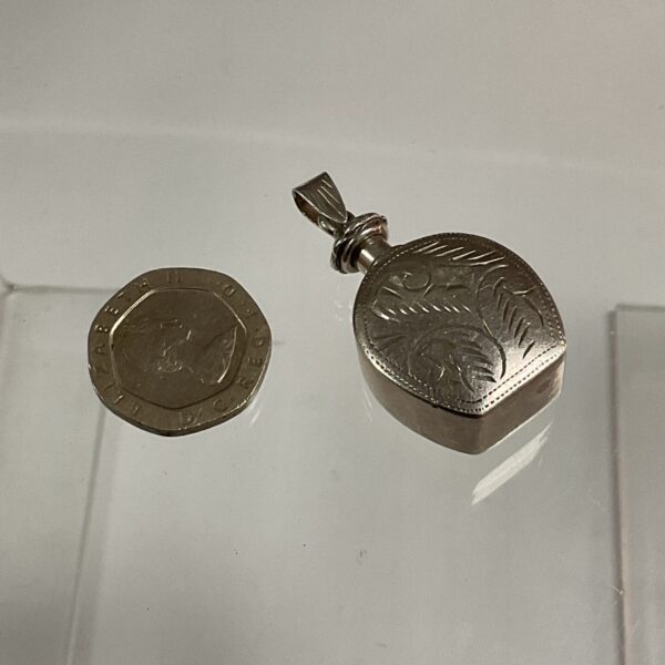 Intricate silver perfume bottle pendant, vintage jewellery collectible.