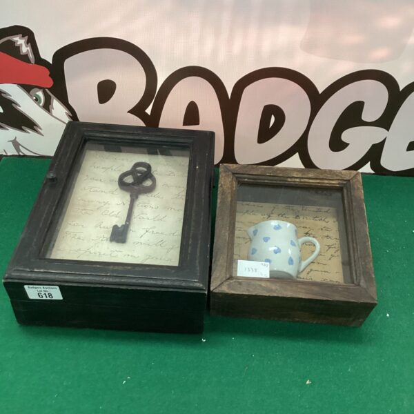 Antique framed display with vintage key and ceramic jug.