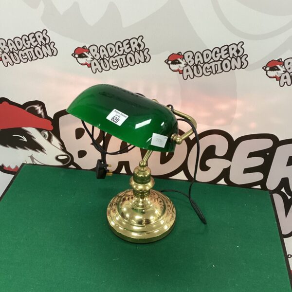 Antique brass bankers lamp with green glass shade for desk lighting.