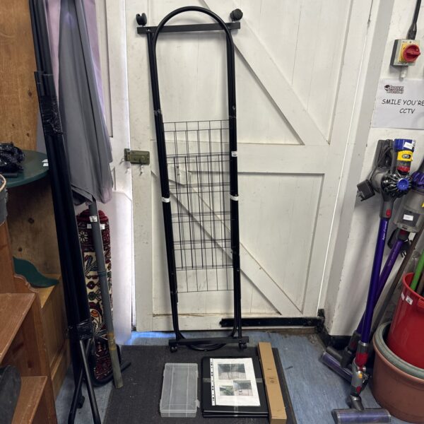 Wire clothes rail with plastic tray for garment storage.