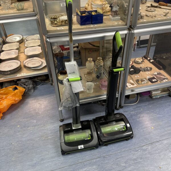 Gtech cordless vacuum cleaner in a display cabinet.