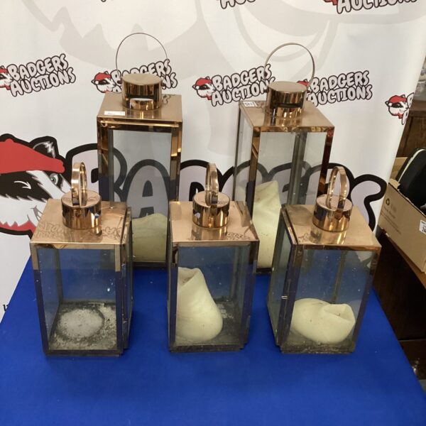 Set of five copper effect candle lanterns for home decor.