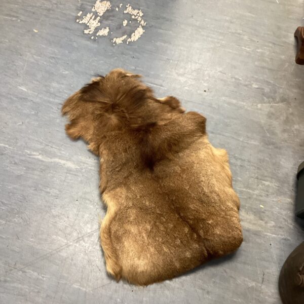Small deer hide rug with natural fur texture.