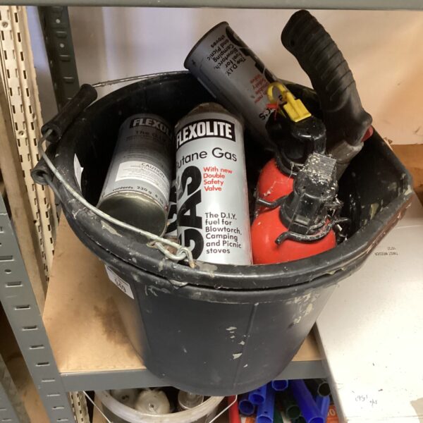Lot of butane gas canisters and a portable burner for camping.