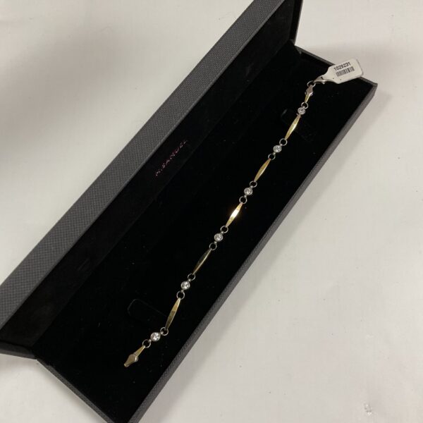 Elegant silver and gold bracelet with white stones.