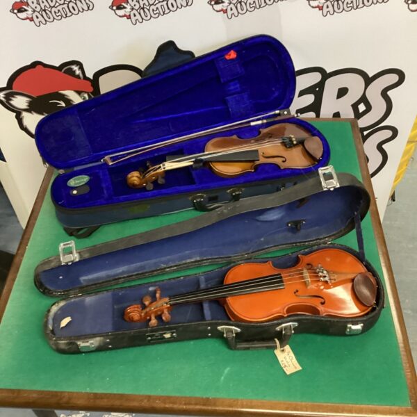 Two children's violins in blue cases, musical instruments.