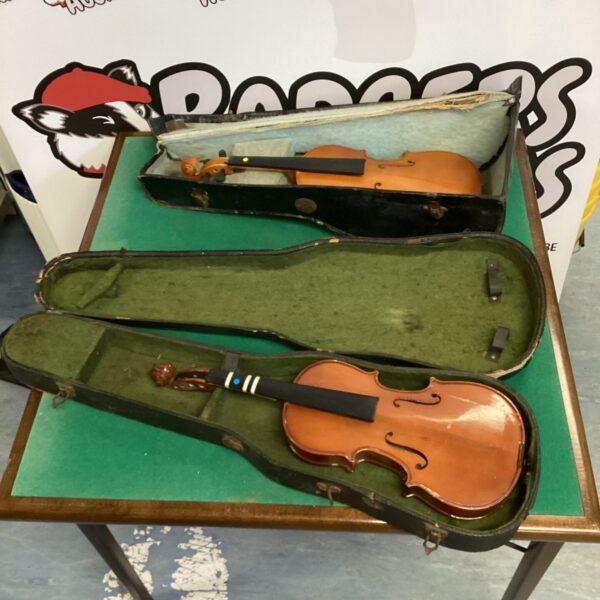 Vintage violin lot with cases, antique stringed instruments.