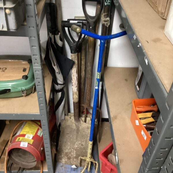 Blue handled spade in a lot of garden tools.