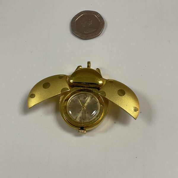 Gold tone ladybird pendant watch with detailed wings.