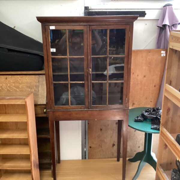 Vintage dark wood display cabinet with glass panel.