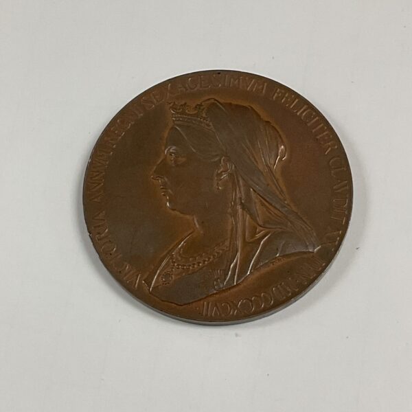 Antique bronze medallion featuring Queen Victoria's portrait.