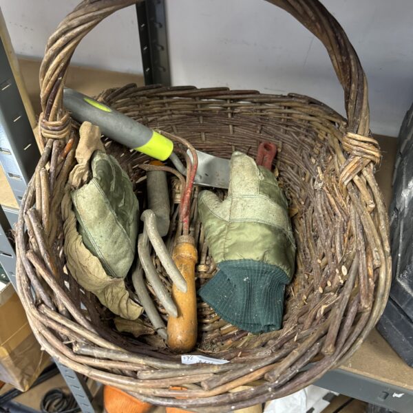 Vintage garden trug overflowing with gardening tools and floral gloves.