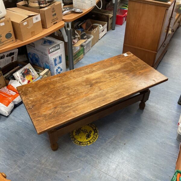 Vintage oak coffee table with visible wood grain and rustic charm.
