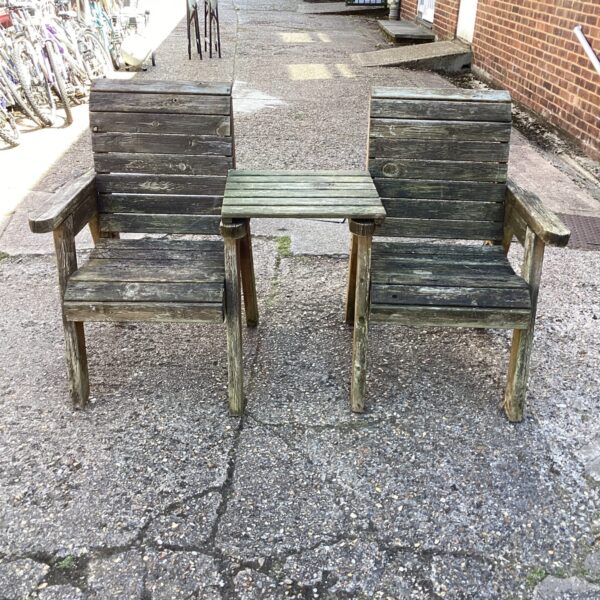 Vintage teak garden chairs and table set in a garden setting.