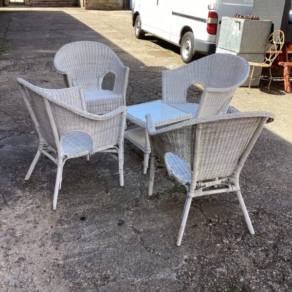 Vintage woven garden furniture set with four chairs and table.