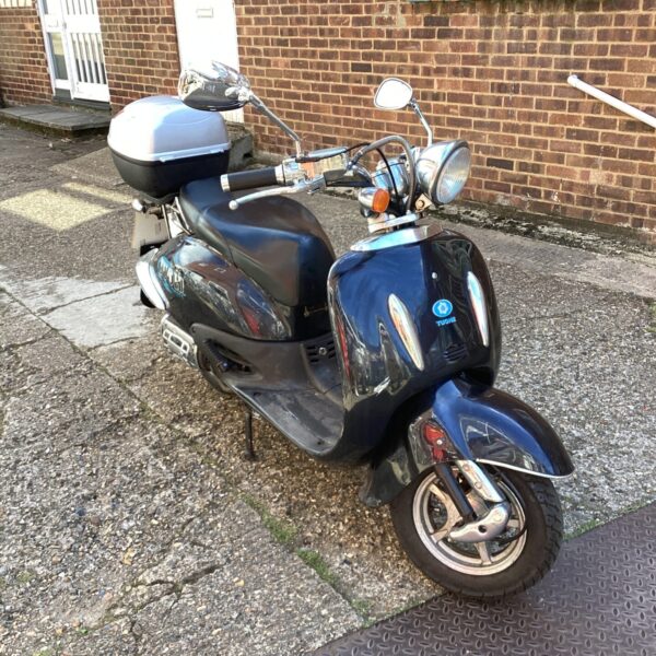 Side view of a classic Tuohe 125cc moped with a top box.