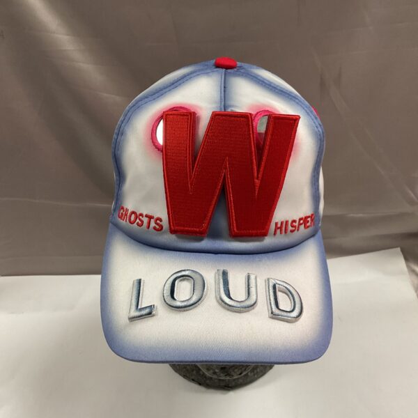 Front view of Walter Van Beirendonck "Loud" cap with red "W" emblem.
