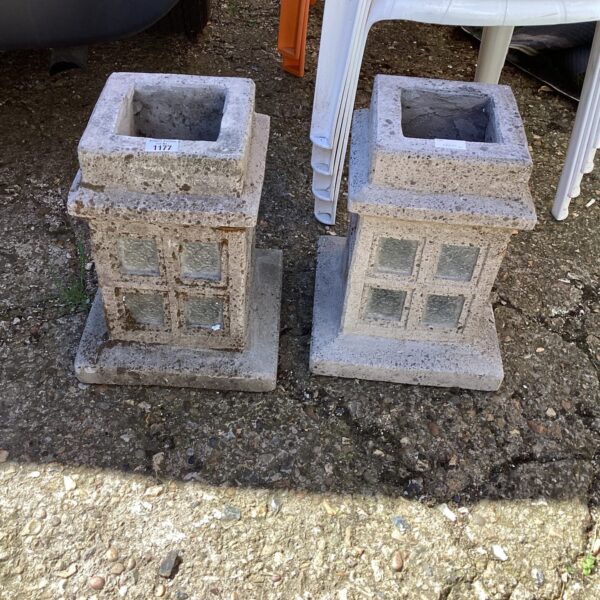 Pair of weathered cement garden planters for outdoor use.