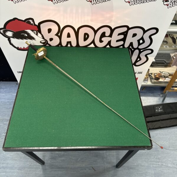 Vintage Spanish Toledo sword displayed on a green surface.