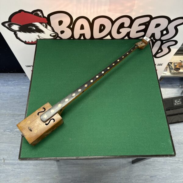 Front view of vintage cigar box guitar with mother of pearl inlay.