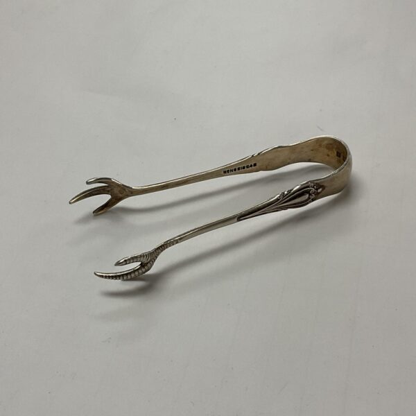 Antique silver sugar tongs with claw design, hallmarked sterling silver.