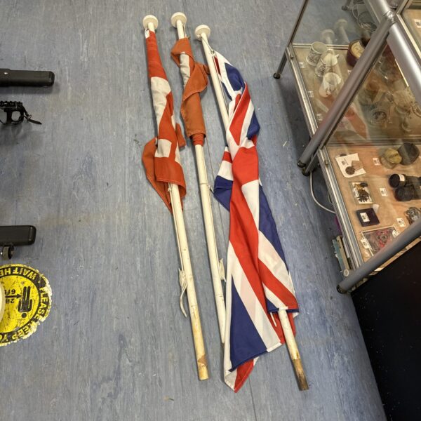 Lot of vintage Union Jack and sale flags on display.