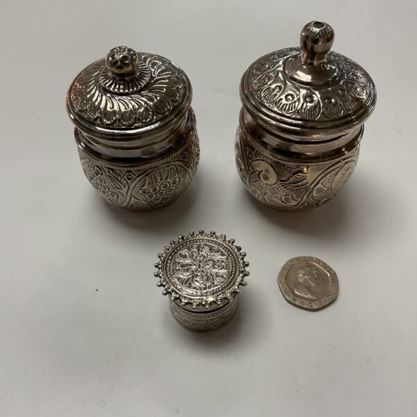 Intricate silver covered pot with floral embossed design.