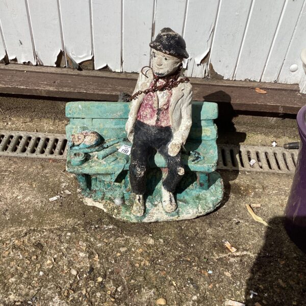 Vintage concrete garden bench ornament with man seated.