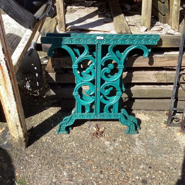 Ornate wrought iron garden table legs with floral details.