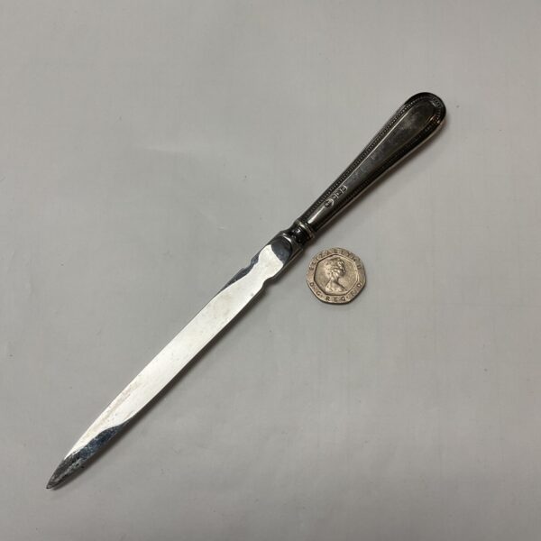 Antique silver letter opener with hallmarked handle and steel blade.