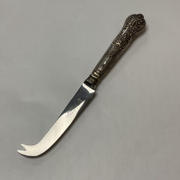 Ornate silver handle of a vintage cheese knife.
