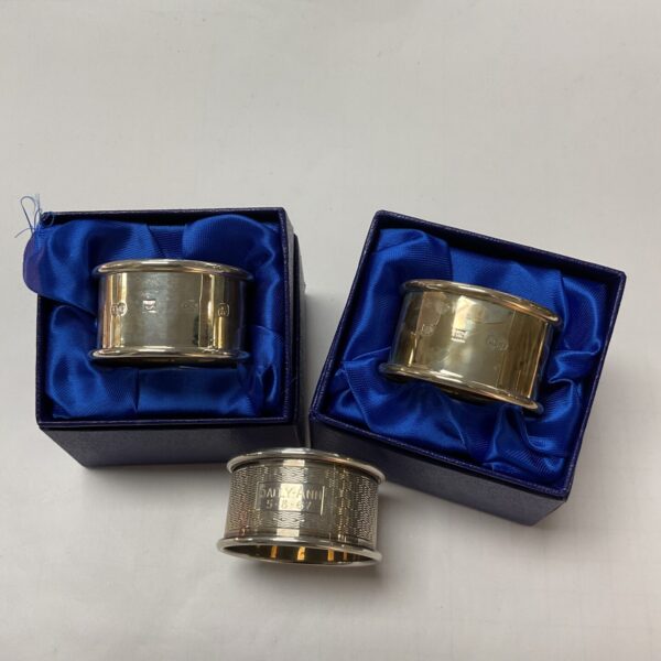 Pair of antique hallmarked silver napkin rings on display.