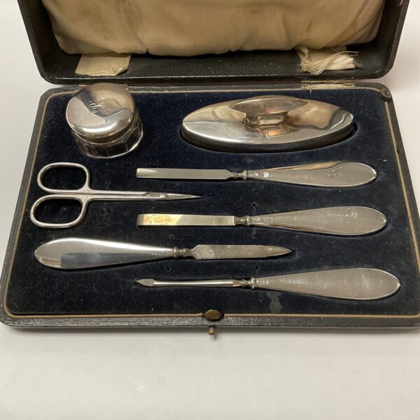 Antique silver manicure set in open case, vintage grooming tools.
