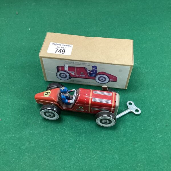 Vintage red tin plate wind-up car, collectible toy.