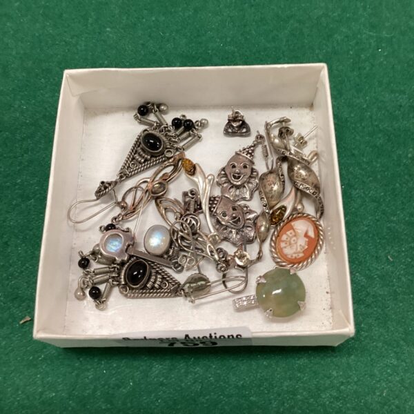 Close-up of a lot of vintage silver earrings with varied designs.