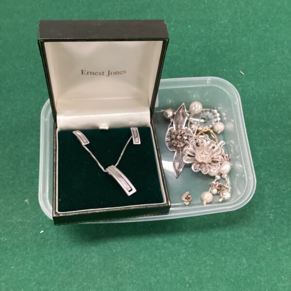 Assorted 925 silver jewellery lot with floral brooches and pendants.