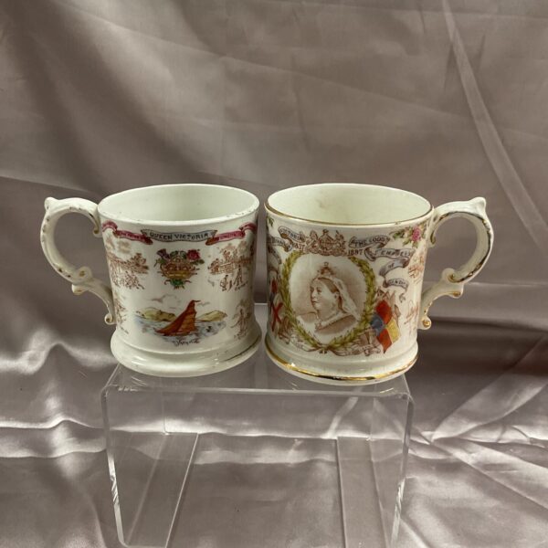 Antique pair of Victoria commemorative mugs on display.