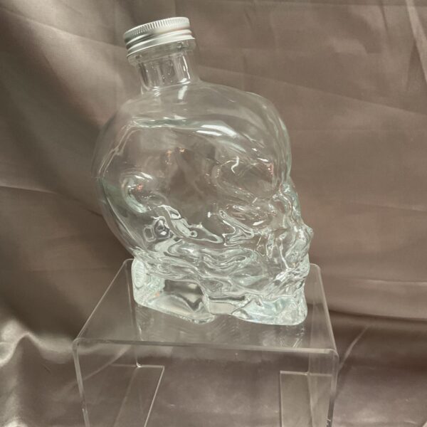 Clear glass devil skull bottle, gothic barware collectible.