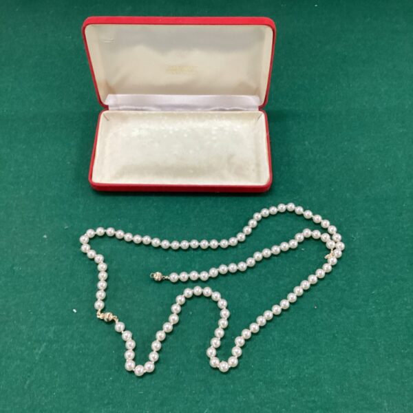 Vintage pearl necklace and bracelet set with gold clasp displayed in box.