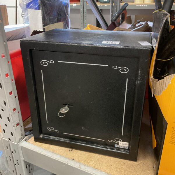 Vintage small metal safe with key, ideal for secure storage.
