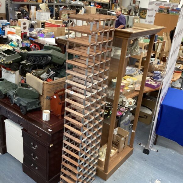 Tall pine and metal wine bottle rack for storage.