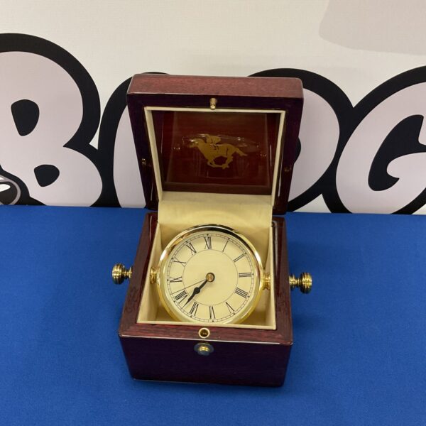 Front view of a vintage horse racing clock.