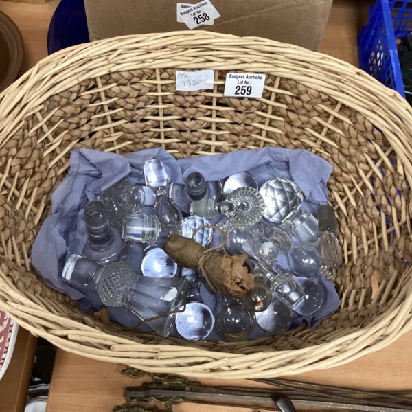 Wicker basket filled with a variety of crystal bottle stoppers.