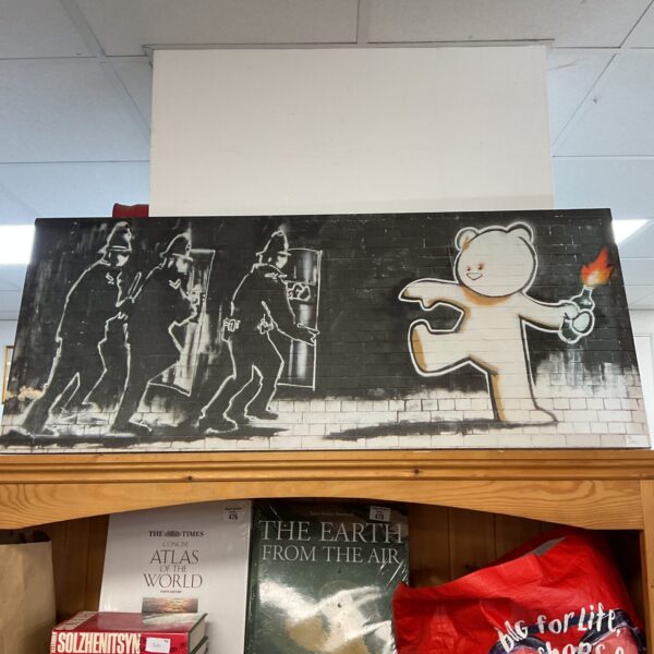 Large Banksy-style canvas print depicting figures on a wall.