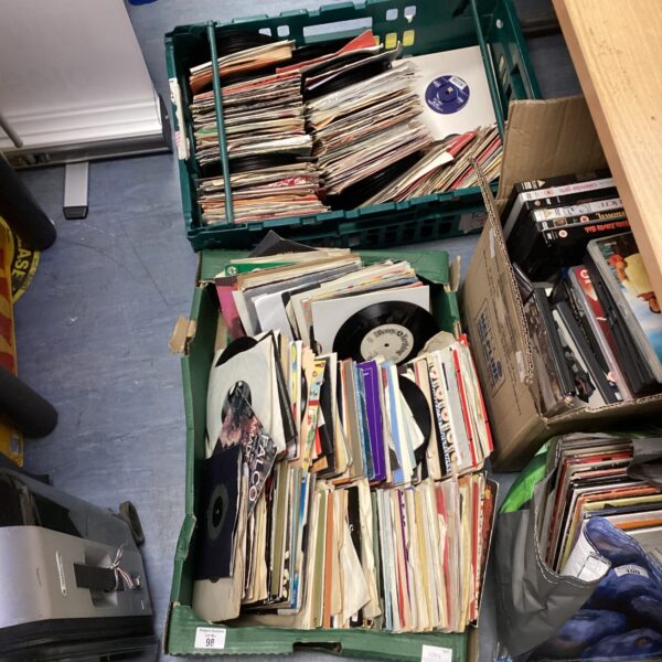 Large lot of vintage 7-inch vinyl records in a crate.