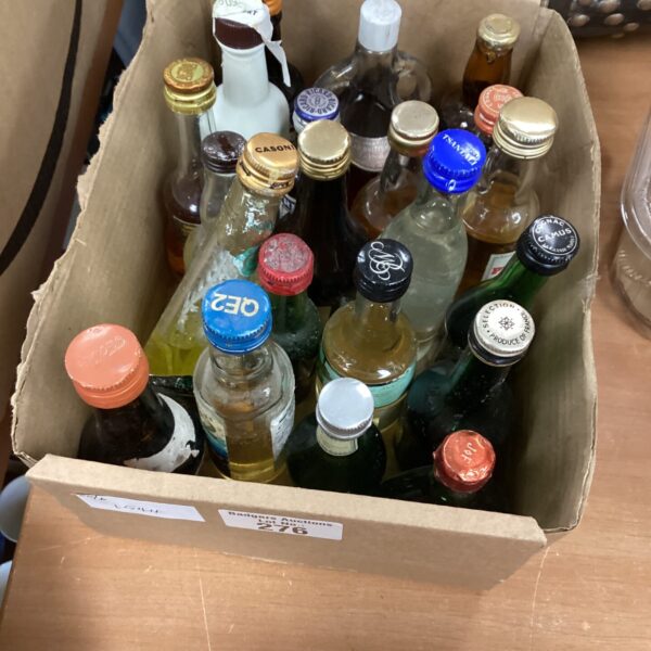 Assorted miniature spirit bottles in a cardboard box.