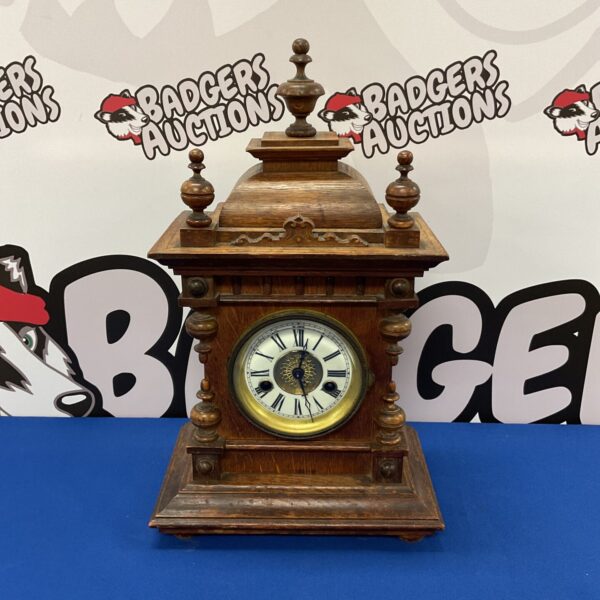 Antique German mantle clock with ornate wooden case.